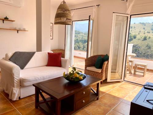 ein Wohnzimmer mit einem Sofa und einem Couchtisch in der Unterkunft La Perla de Frigiliana Suites & Villa in Frigiliana