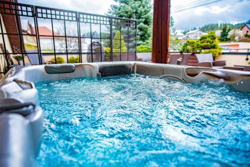 a hot tub on a balcony with blue water at Penzion a restaurace Staré Časy in Horní Bečva