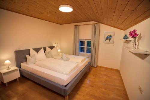 a bedroom with a large bed with a wooden ceiling at Glögglhof in Lana