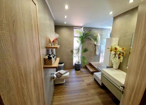 a hallway with a bathroom with a toilet and flowers at Villa Gala in Balíon