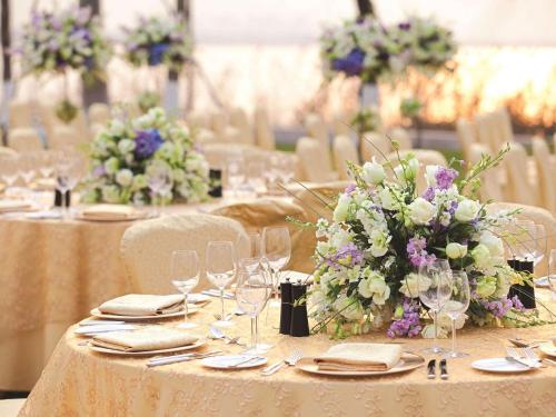 a group of tables with wine glasses and flowers at Fairmont Yangcheng Lake in Kunshan
