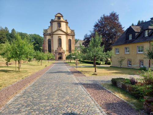 a stone road leading to a building with a tower at Eifel Duitsland fraai vakantiehuis met tuin in Eisenschmitt