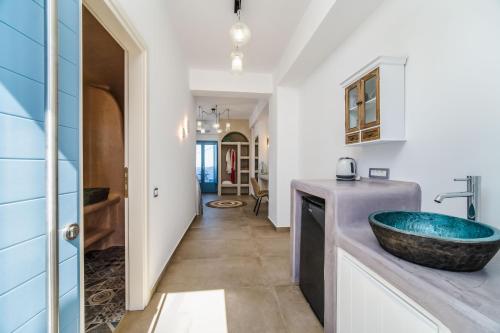 un bagno con lavandino blu e corridoio di Aegean Blue Suites a Pyrgos