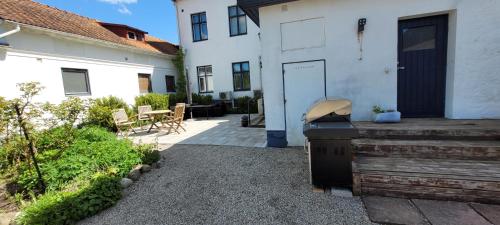 a backyard with a bbq smoker next to a house at Svea hotell, Vollsjö in Vollsjö