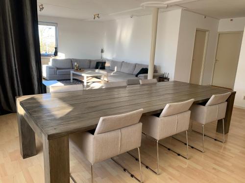 uma sala de estar com uma mesa de madeira e cadeiras em Apartments Zaanse Schans and Amsterdam em Wormer