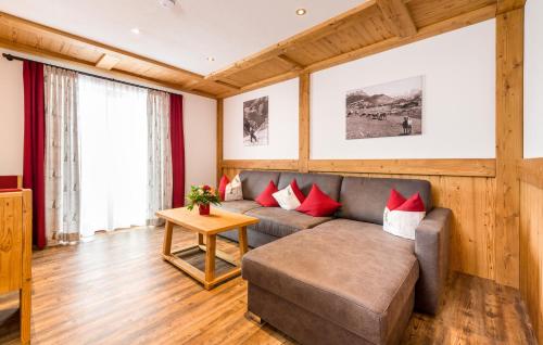 a living room with a couch and red pillows at Tyroler Hof in Grän