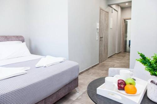 een slaapkamer met een bed en een dienblad met fruit op een tafel bij D Spacious Brand New Studio Ideal for 2 D in Athene