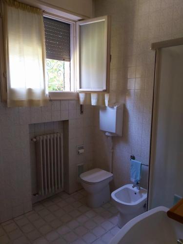 baño con aseo y lavabo y ventana en B&b rustic chic Casa Salva, en Molinella