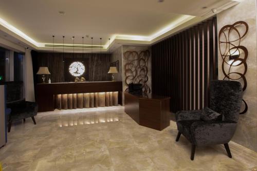 a lobby with a clock on the wall and a chair at Seas Hotel Amman in Amman