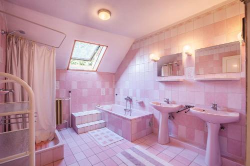 a pink bathroom with two sinks and a bath tub at Martha apartman in Fonyód