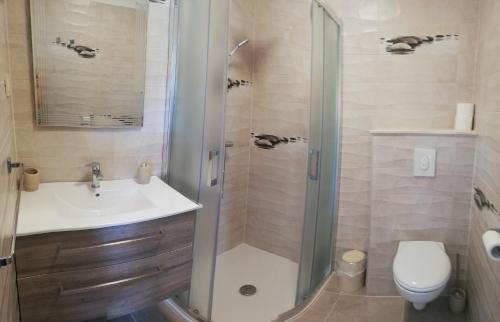 a bathroom with a shower and a sink and a toilet at Riviera Rooms and Apartments in Rab