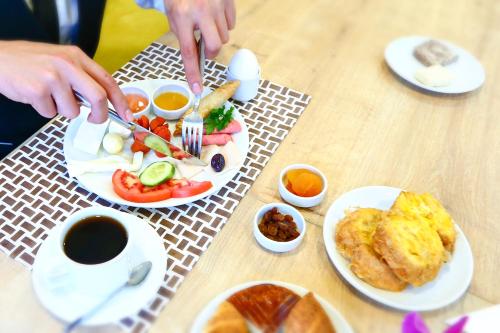 a table with plates of breakfast food and a cup of coffee at Burçman Hotel Vişne in Yıldırım