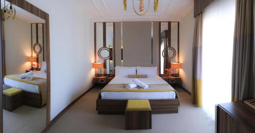 a bedroom with two beds and a mirror at Burçman Hotel Vişne in Yıldırım