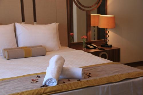 a hotel room with a bed with towels on it at Burçman Hotel Vişne in Yıldırım