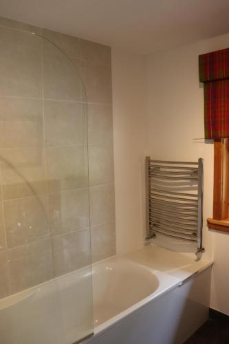 eine weiße Badewanne im Bad mit Dusche in der Unterkunft Lodge 38 Rowardennan , Loch Lomond in Glasgow