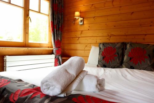 1 dormitorio con 1 cama con toallas en Lodge 38 Rowardennan , Loch Lomond, en Glasgow