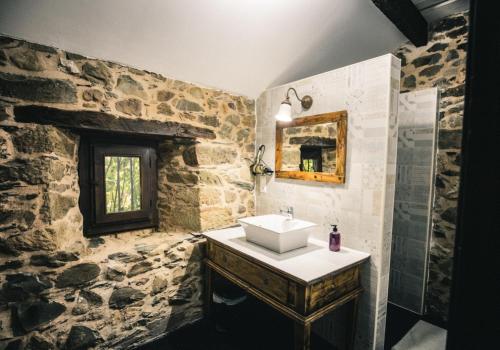 Baño de piedra con lavabo y espejo en La Casa Grande Del Valle, en El Valle