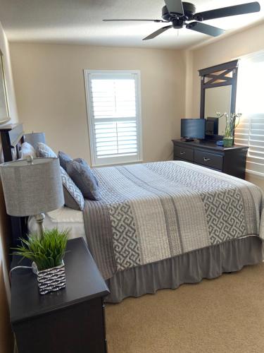 a bedroom with a bed and a ceiling fan at Cozy Villa With South Facing Pool in Davenport
