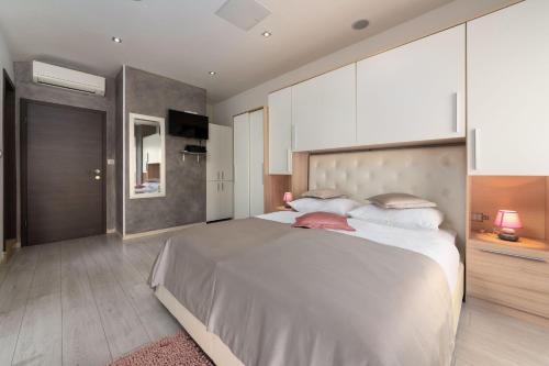 um quarto com uma cama grande e armários brancos em Apartments Deny em Vrsar