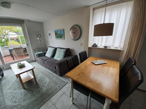 ein Wohnzimmer mit einem Sofa und einem Tisch in der Unterkunft Garden cottage Domburg in Domburg