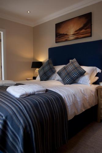 a large bed with a blue headboard in a room at Langtrys in Blackpool