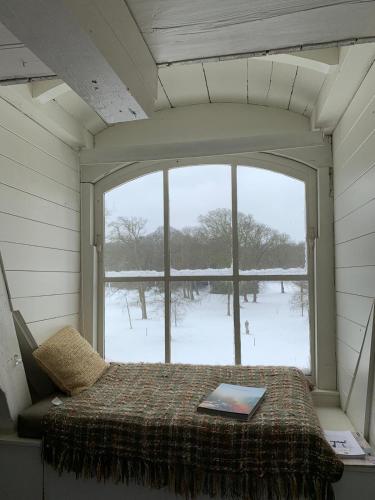 a bed in a room with a large window at Eco Hotel Plantage Rococo in Velsen-Zuid