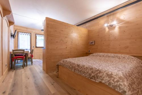 een slaapkamer met een bed en een tafel. bij Cesa Palue in Rocca Pietore