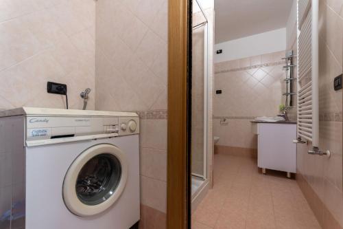a washer and dryer in a small bathroom at Casa NeveXenne & La Casa di Blek in Alleghe