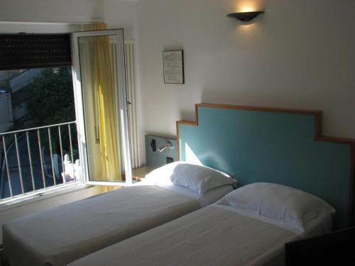 a bedroom with two beds and a large window at Hotel Belvedere in Portovenere