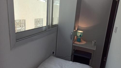 a small bedroom with a bed and a window at Cozy Rooms and Small Partitions for Men guests in Dubai in Dubai