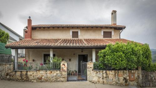 une maison en pierre avec une clôture devant elle dans l'établissement Casa Rural Laura, à Miranda del Castañar