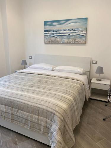 1 dormitorio con 1 cama y una pintura en la pared en Affittacamere La Riviera, en Levanto