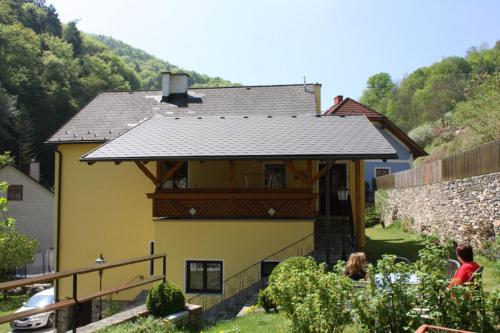 una gran casa amarilla con techo negro en Ferienwohnung Helga Bergkirchner, en Schwallenbach