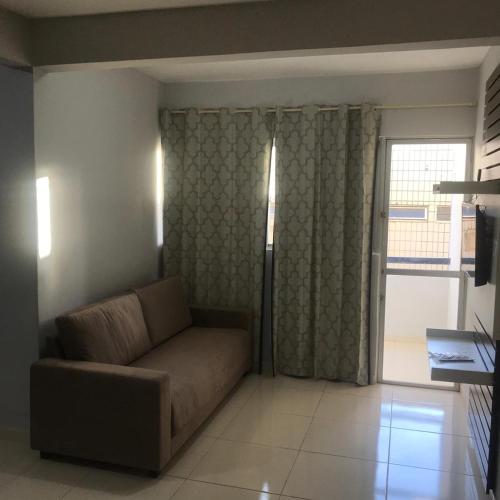 a living room with a couch and a window at Ed. Oliveiro Lucena in João Pessoa