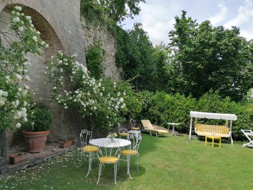 a garden with chairs and a table and a table and chairs at Residenza Le Peonie in Todi