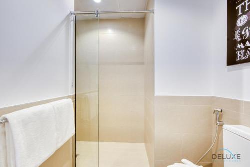 a shower with a glass door in a bathroom at Spotless 1BR at UNA Town Square Dubailand by Deluxe Holiday Homes in Dubai