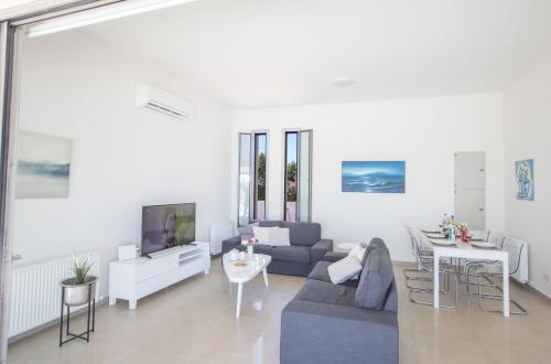 un salon avec un canapé et une télévision dans l'établissement Leda Villa, à Protaras
