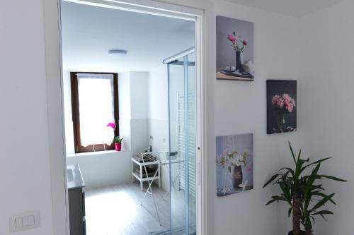 ein Badezimmer mit einer Glastür und einem Spiegel in der Unterkunft Casa CarMa in Porto Ceresio