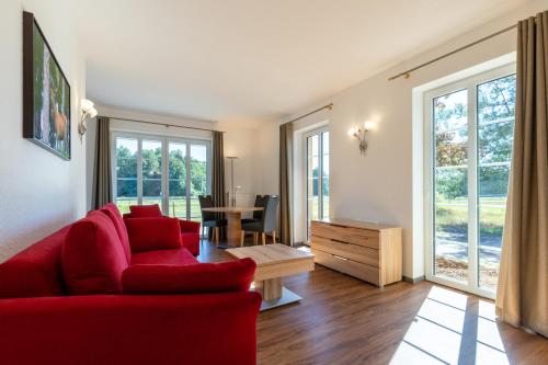 a living room with a red couch and a table at Hotel TraumzeitHof in Eschede