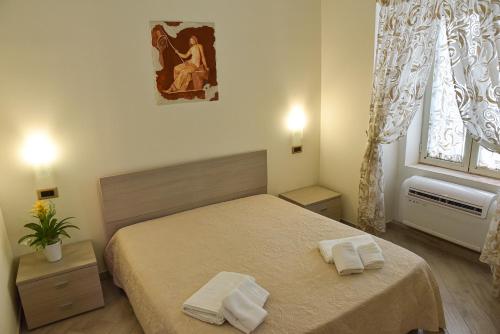 una camera da letto con un letto e due asciugamani di Domus Carolina a Pompei