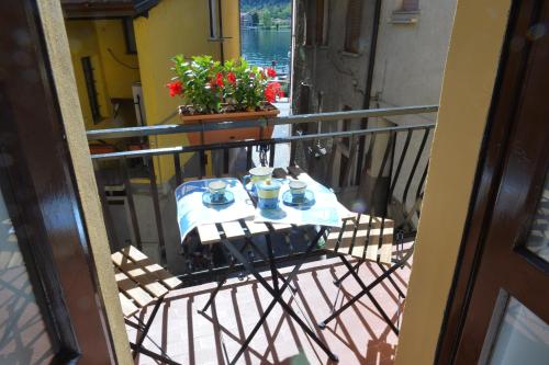a balcony with a table with tea cups on it at Casa CarMa in Porto Ceresio