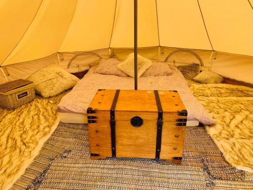a bed in a tent with a wooden box on it at Murimäe Winery glamping in Otepää