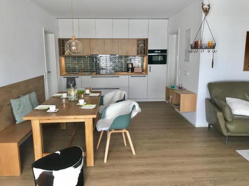 a kitchen and living room with a table and chairs at LÜFTLE neue gemütliche große Familien Ferienwohnung im Allgäu in Wolfegg