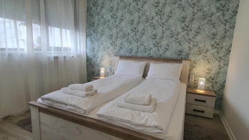 a bedroom with a bed with towels on it at Apartments Spring in Čačak