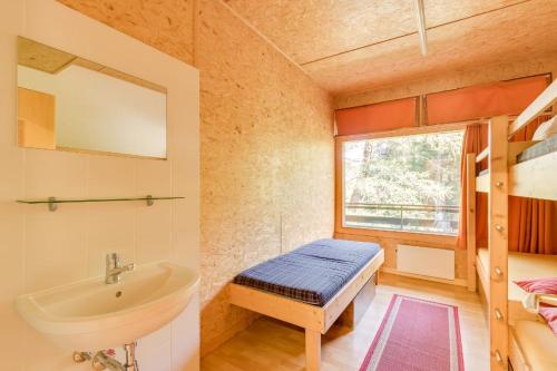 łazienka z umywalką, łóżkiem i oknem w obiekcie Les Louerettes w mieście Siviez