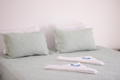 two slippers are sitting on a bed with pillows at Pousada Refúgio das Estrelas - Vista para o Mar in Ilhabela