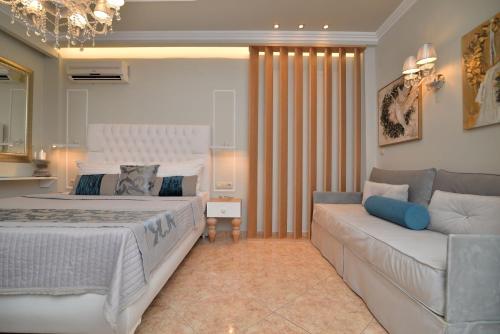 a bedroom with a large bed and a couch at Epavlis Luxury apts in Leptokaria