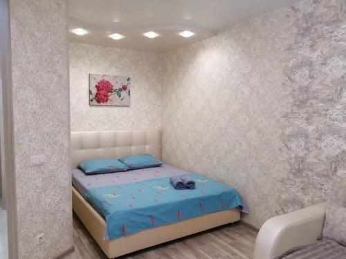 ヴォルシスキーにあるApartment on Mira 75のベッドルーム1室(青い枕のベッド1台付)
