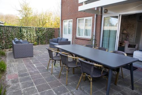 een zwarte tafel en stoelen op een patio bij Wulkpad 23 in Zoutelande