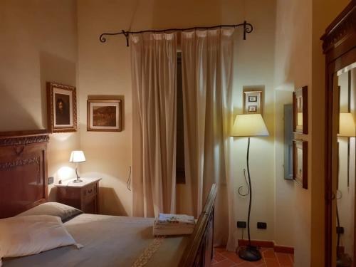 a bedroom with a bed and a lamp and curtains at Fattoria Michela in Matraia